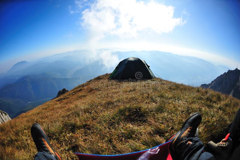 First person shot of tent on alpine cliff edge royalty free stock image
