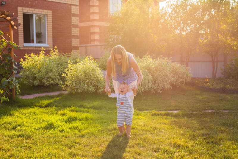 First steps of little adorable toddler boy, Happy and cute baby learning to walk with mother, mother`s day concept royalty free stock photos First steps of little adorable toddler boy, Happy and cute baby learning to walk with mother, mother`s day concept royalty free stock photos