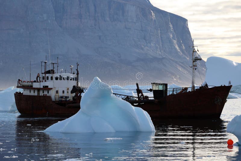 Fischschlepper inmitten von Eisbergen im Hafen von uummannaq in uummannaq Fjord Greenland denmark