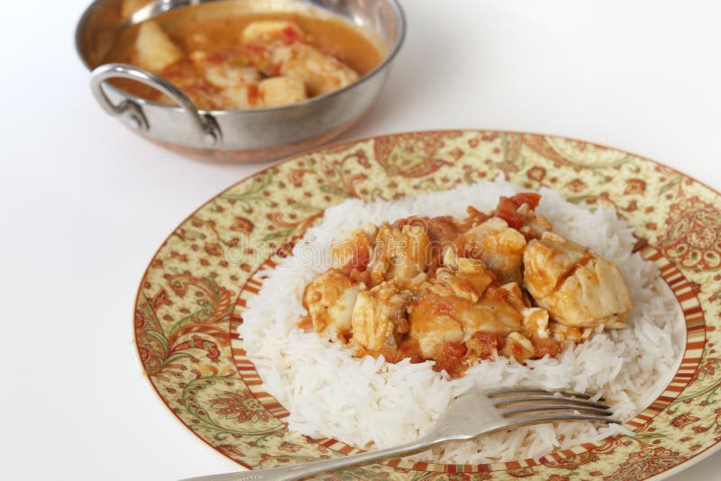 Basic fish curry, in a spicy tomato and coconut milk sauce, served on a bed of basmati rice, with a kadai (or karahi or wok) serving bowl. Basic fish curry, in a spicy tomato and coconut milk sauce, served on a bed of basmati rice, with a kadai (or karahi or wok) serving bowl.