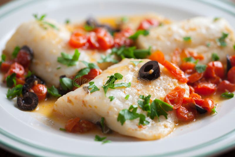 Fish fillet with cherry tomatoes and olives royalty free stock photo