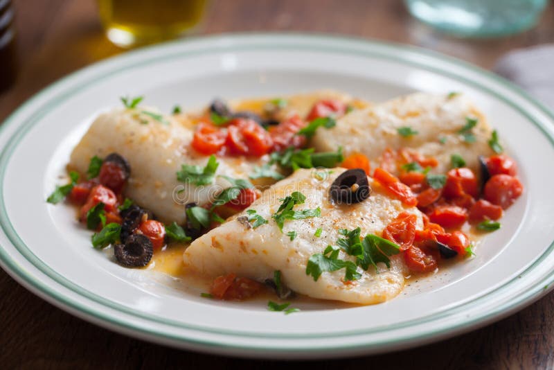 Fish fillet with cherry tomatoes and olives stock image