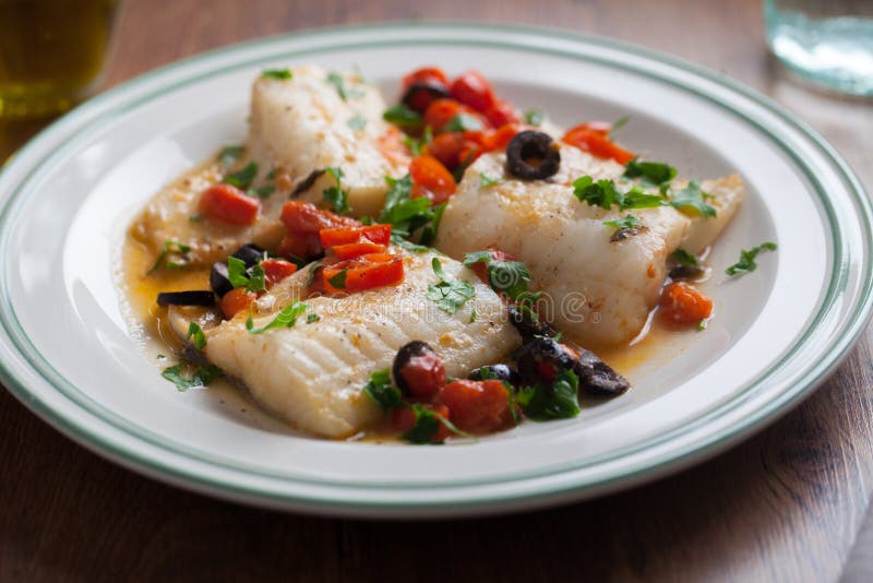 Fish fillet with cherry tomatoes and olives royalty free stock photos