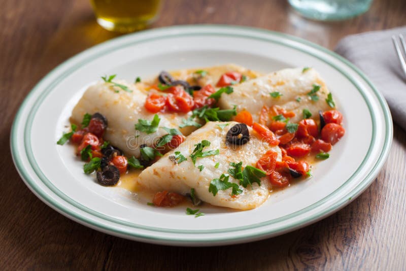 Fish fillet with cherry tomatoes and olives royalty free stock photo