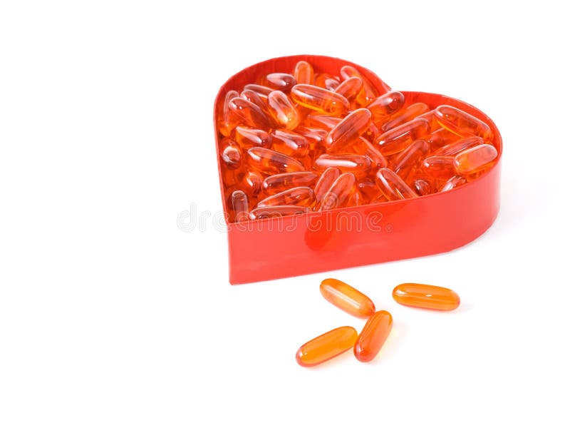 Fish oil pills in red heart shaped box royalty free stock photo Fish oil pills in red heart shaped box royalty free stock photo