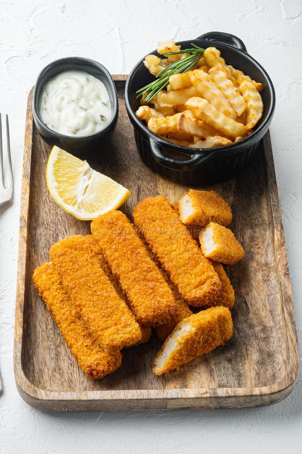 Fish Sticks with vegetables, on wooden tray, on white background stock photos