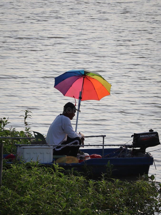 Fisherman on the Boat with Umbrella Editorial Photography - Image