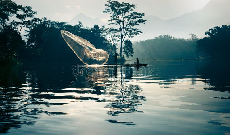 Fisherman Casting Out His Fishing Net in the River. Stock Photo