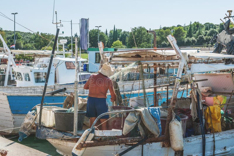 Fisherman preparing an old fishing boat to go to sea. The quota for catching fish. Small business