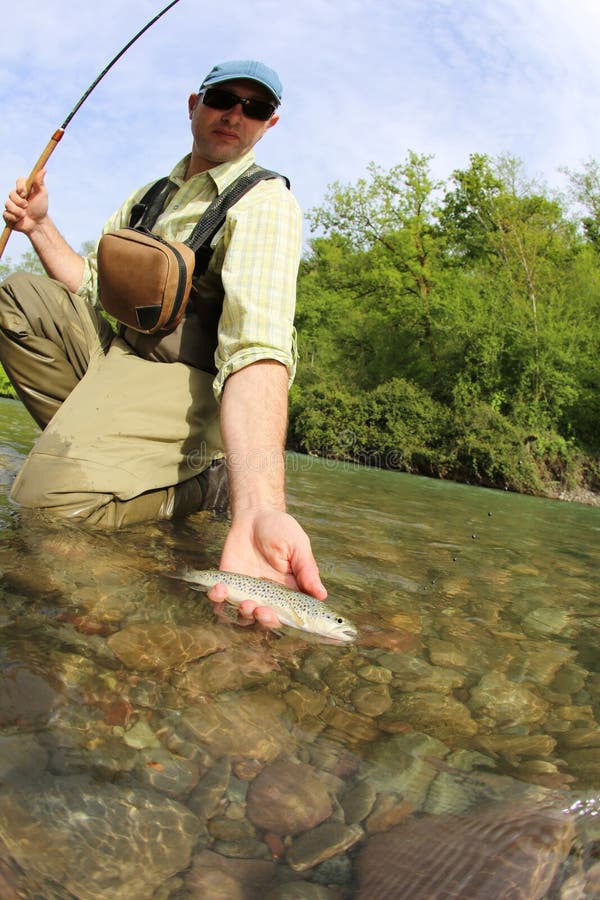 Fisherman in river catching trout stockbild Fisherman in river catching trout stockbild