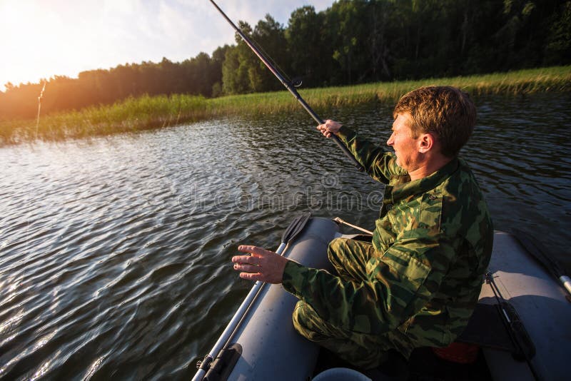 Fisherman on Rubber Boat Catching Fish on the Lake. Hobby. Stock Image