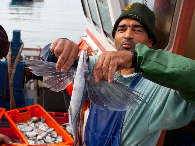 Fisherman shows a flying fish