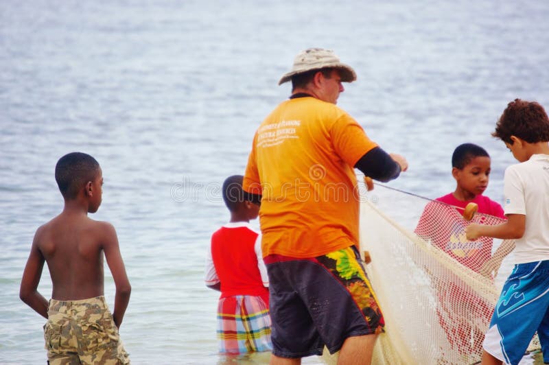 Fisherman teaches children to use the net