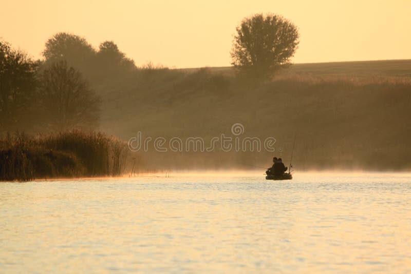 Fishermen in a boat catching fish early in the morning