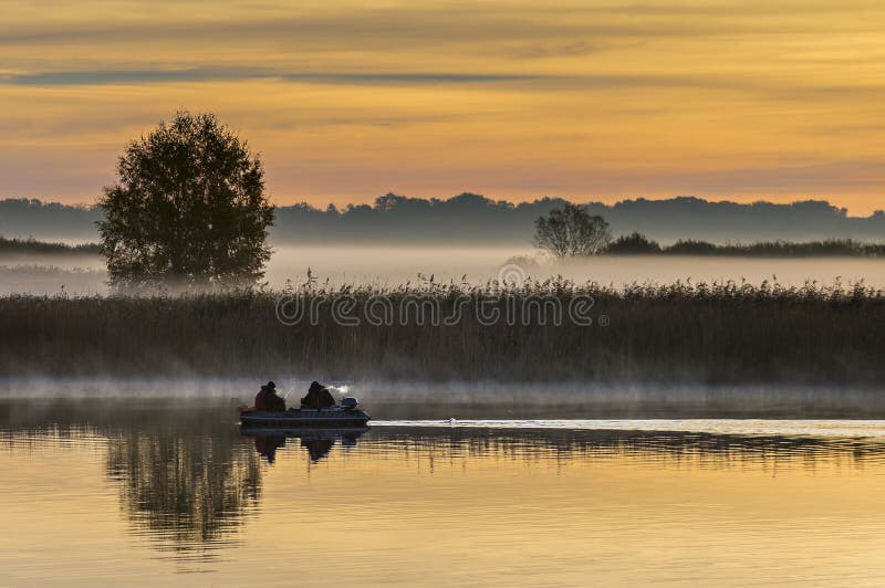 Fishermen on a river at dawn