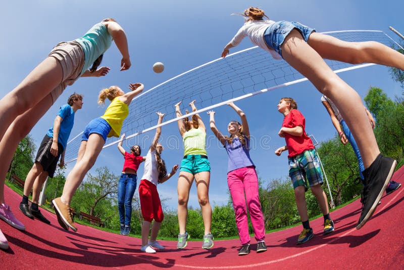 Fisheye view of teens playing volleyball outside