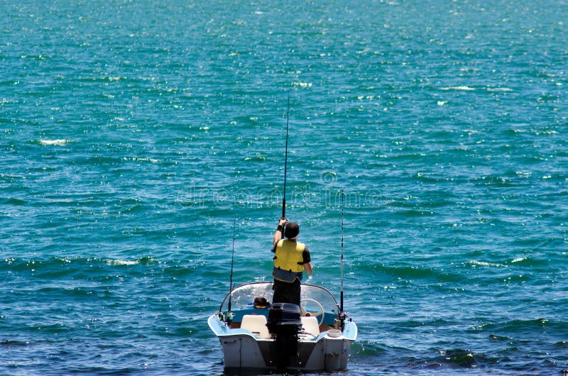 Fishing boat with fisherman holding rod in action.