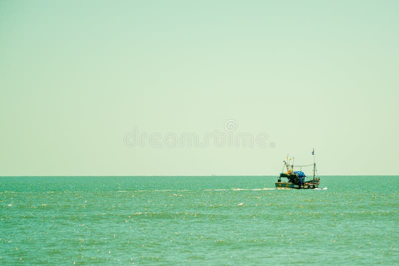 Fishing Boat Sailing Away into the Distance of the Ocean Stock Photo