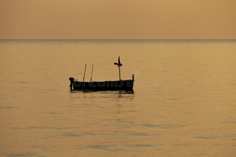 Fishing boat silhouette moored offshore empty, no people around