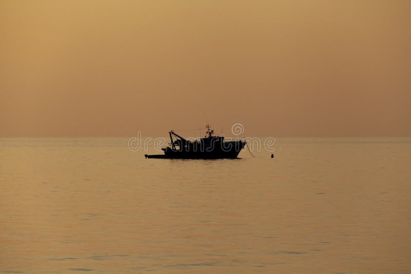 Fishing boat moored silhouette offshore daylight no people around. Fishing boat moored silhouette offshore daylight no people around