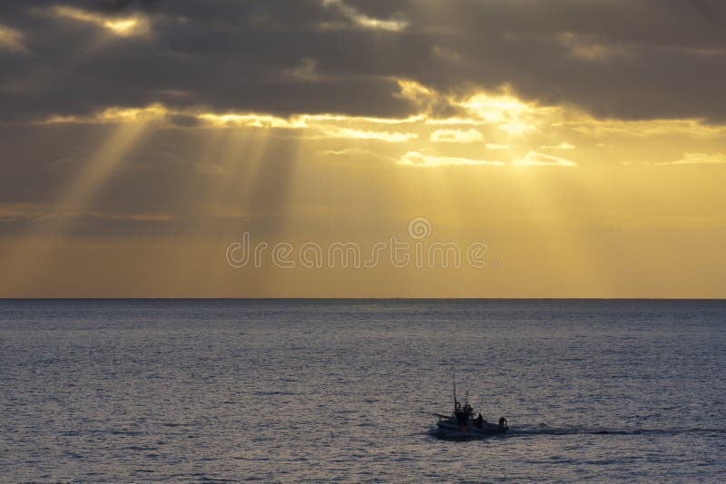 Fishing boat returning to the harbour in the azores at sunset. Fishing boat returning to the harbour in the azores at sunset