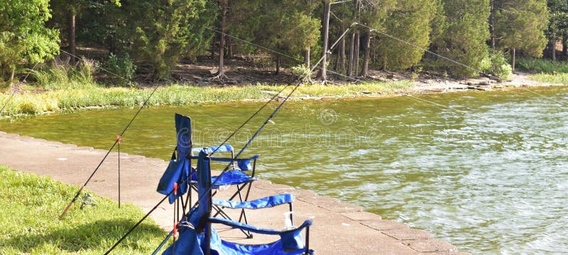 Your fishing chair awaits you in a secluded cove on the shore of J Percy Priest Lake in Nashville, Tennessee. This large freshwater lake stretches through 3 counties. The early morning sun peaks through the clouds and reflects across the water. Your fishing chair awaits you in a secluded cove on the shore of J Percy Priest Lake in Nashville, Tennessee. This large freshwater lake stretches through 3 counties. The early morning sun peaks through the clouds and reflects across the water.