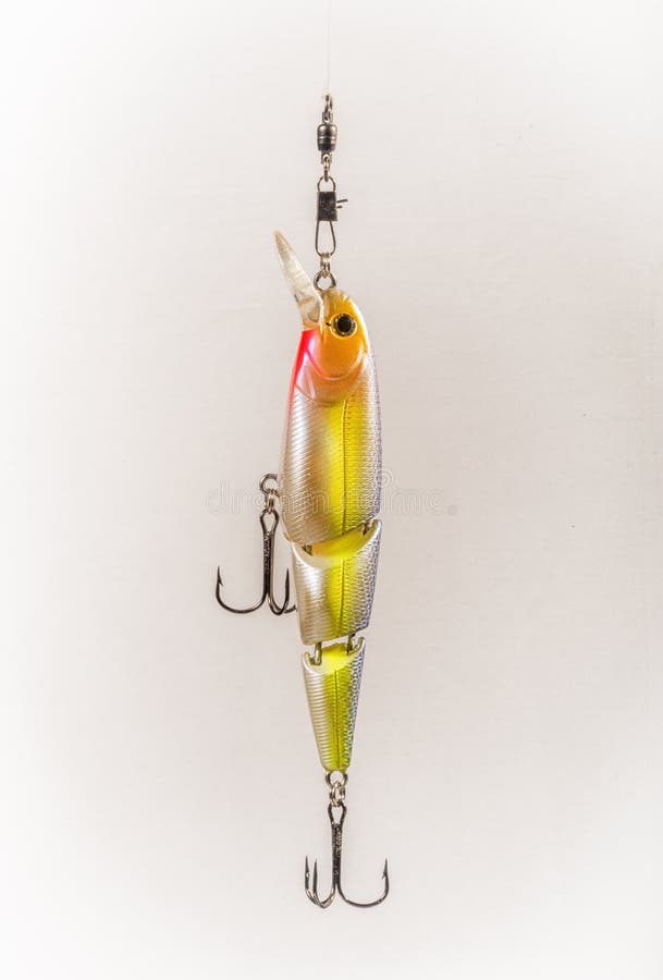 Fishing Lure with Treble Hooks. A fishing lure imitating a little colorful fish with two treble hooks, displayed on a non-distracting light background stock images Fishing Lure with Treble Hooks. A fishing lure imitating a little colorful fish with two treble hooks, displayed on a non-distracting light background stock images