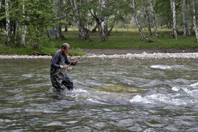 Fishing on the mountain river fishing rod. Fisherman fishing in the mountains. Trout fishing. royalty free stock image Fishing on the mountain river fishing rod. Fisherman fishing in the mountains. Trout fishing. royalty free stock image