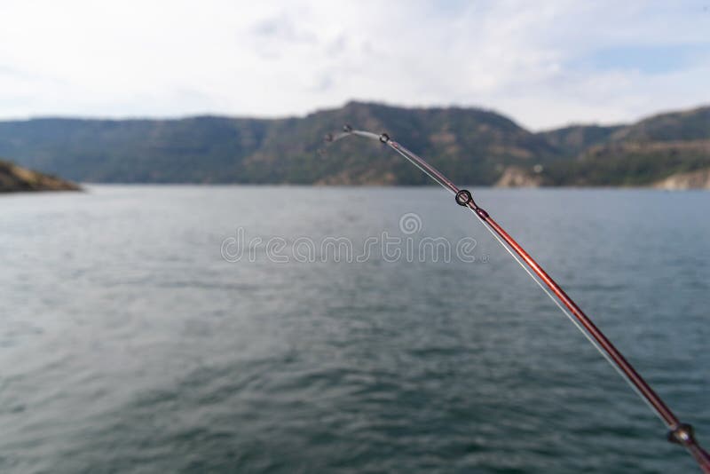 Fishing pole with line in the water on Lake Roosevelt in Washington State