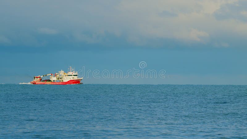 Static View. Fishing Ship In Open Sea Water. Beautiful Fishing Boat With The Blue Sea On Background. Static View. Fishing Ship In Open Sea Water. Beautiful Fishing Boat With The Blue Sea On Background.