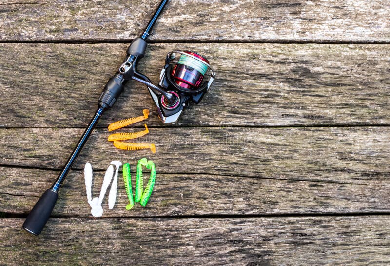 Fishing accessories, spinning, fishing reel, silicone lures on a wooden background stock photo Fishing accessories, spinning, fishing reel, silicone lures on a wooden background stock photo