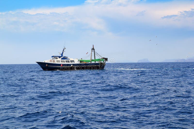 Fishing trawler professional boat working in blue ocean sea