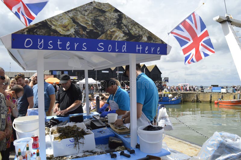 Fishmongers prepare and shuck oysters for visitors at the Whitstable Oyster Festival