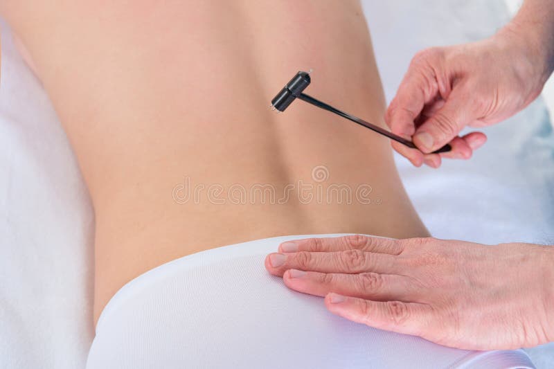 Fisioterapeuta que faz para trás a massagem no escritório médico com um martelo da acupuntura imagem de stock royalty free Fisioterapeuta que faz para trás a massagem no escritório médico com um martelo da acupuntura imagem de stock royalty free