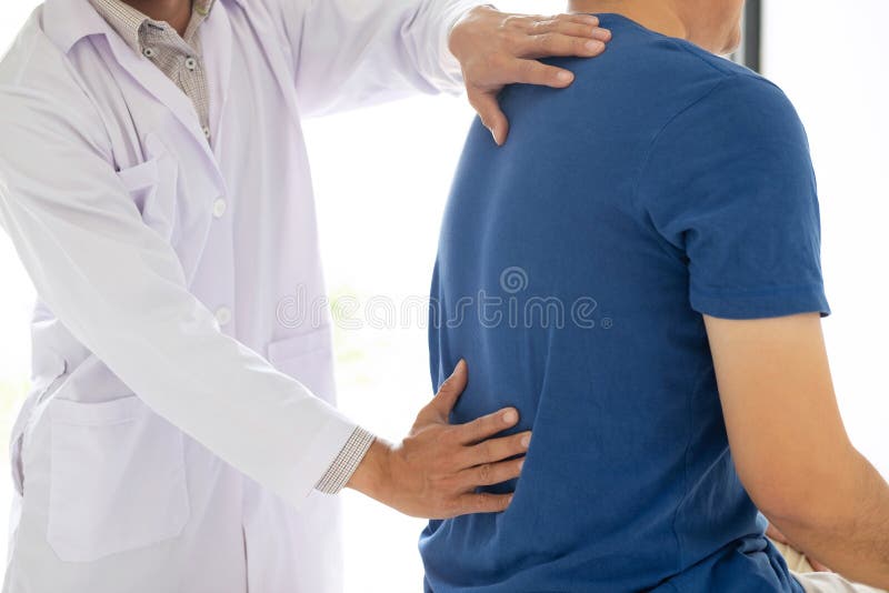 Doctor physiotherapist treating lower back pain patient after while giving exercising treatment on stretching in the clinic, Rehabilitation physiotherapy concept. Doctor physiotherapist treating lower back pain patient after while giving exercising treatment on stretching in the clinic, Rehabilitation physiotherapy concept