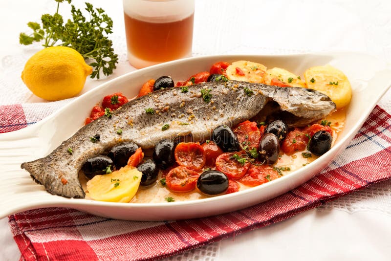 Fisk med tomater och oliv arkivfoton