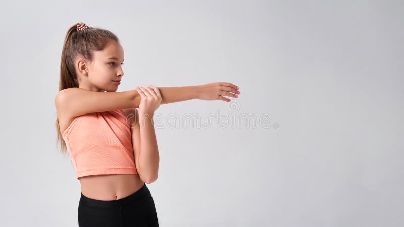 Fit kid. Flexible cute little girl child looking aside while doing exercise  on a white background. Sport