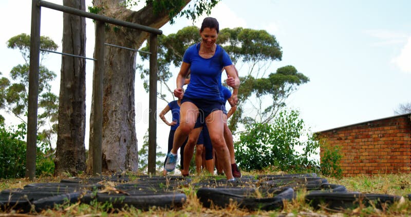 Fit people practicing tire obstacle course training 4k