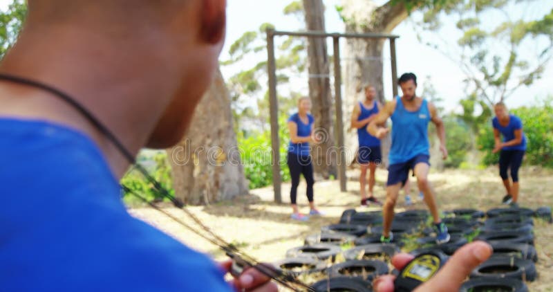 Fit people practicing tire obstacle course training 4k