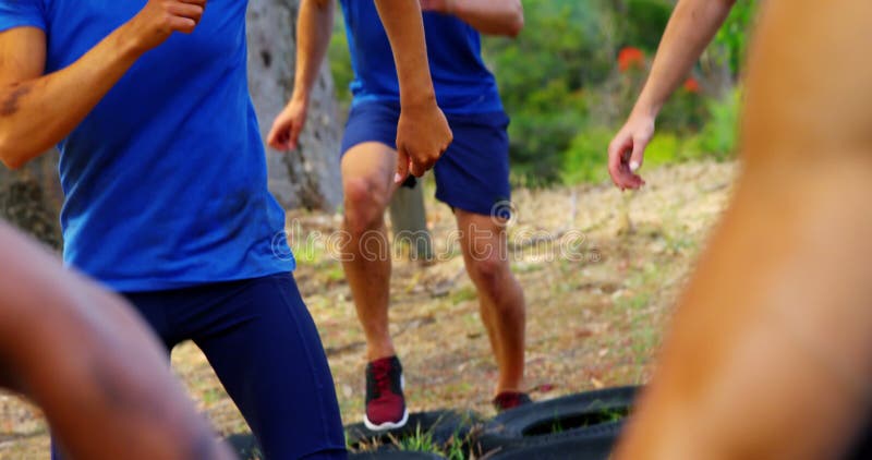 Fit people practicing tire obstacle course training 4k