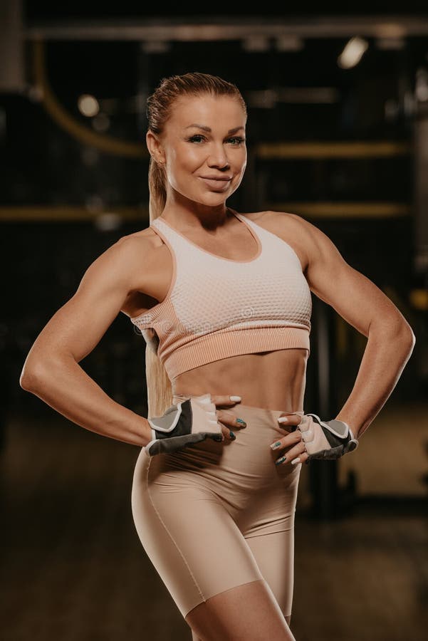 A sporty woman with long blonde hair is doing a chest workout on the cable  machine in a gym. A girl is training her pectoral muscles Stock Photo -  Alamy