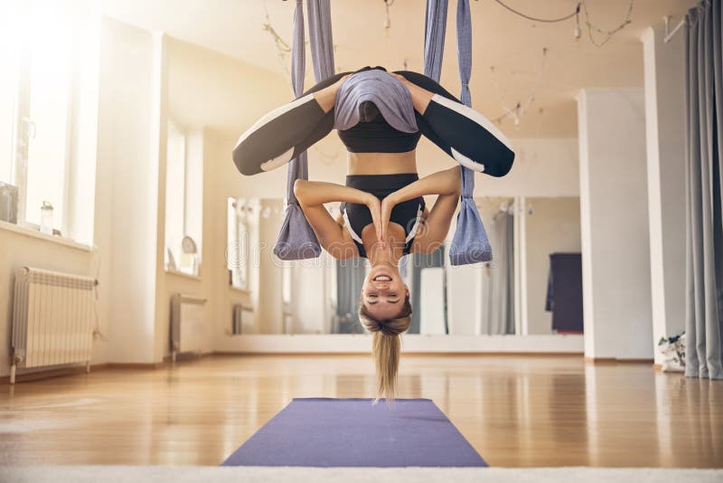 Fit woman hanging upside down in a hammock stock photos
