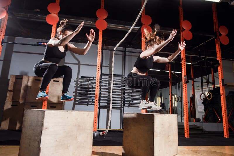 Fit young woman box jumping at a cross fit gym