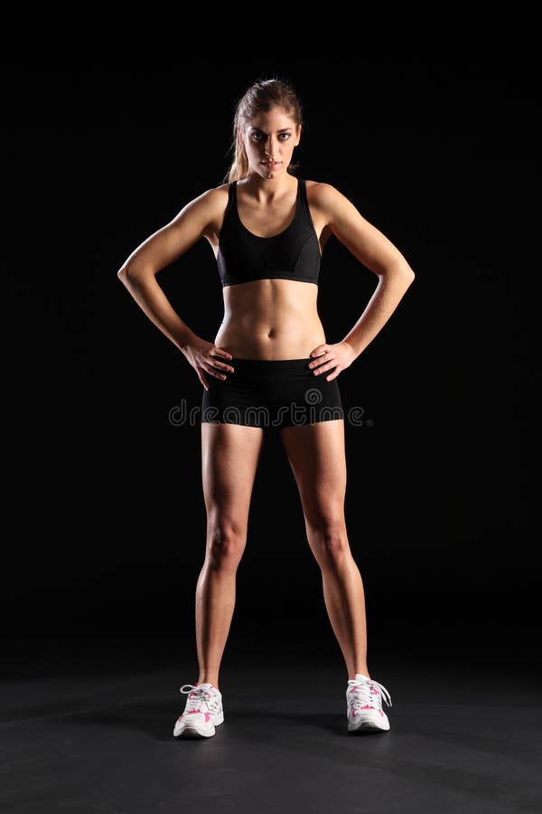 Fit young woman standing in black sports outfit