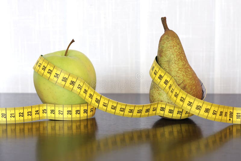 Fita métrica, maçã e pera fotografia de stock royalty free