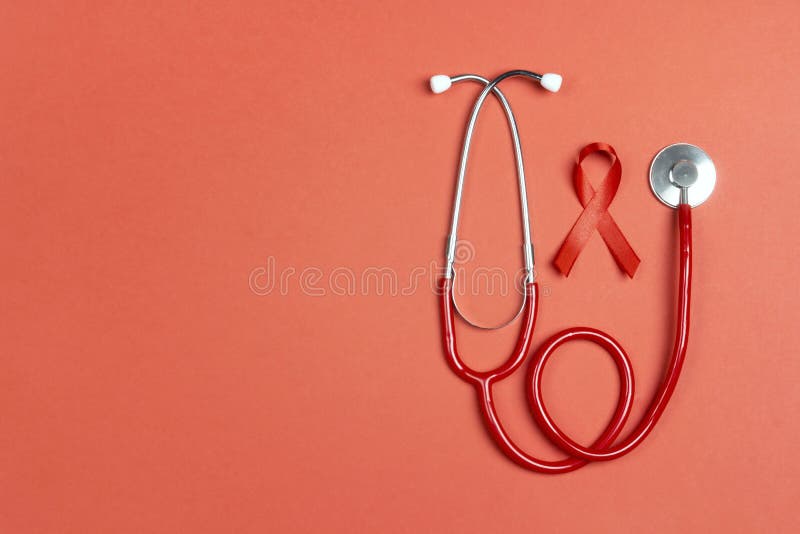 Fita vermelha como símbolo da consciência da aids com estetoscópio em fundo vermelho 1 de dezembro Conceito do Dia Mundial da SID