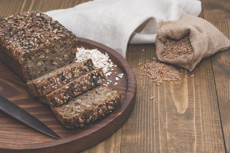 Fitness bread. A loaf of fresh rustic whole meal rye bread, sliced on a wooden board, rural food background. Top view. Copy space.