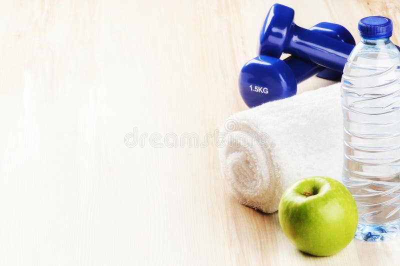 Fitness concept with dumbbells, green apple and water bottle