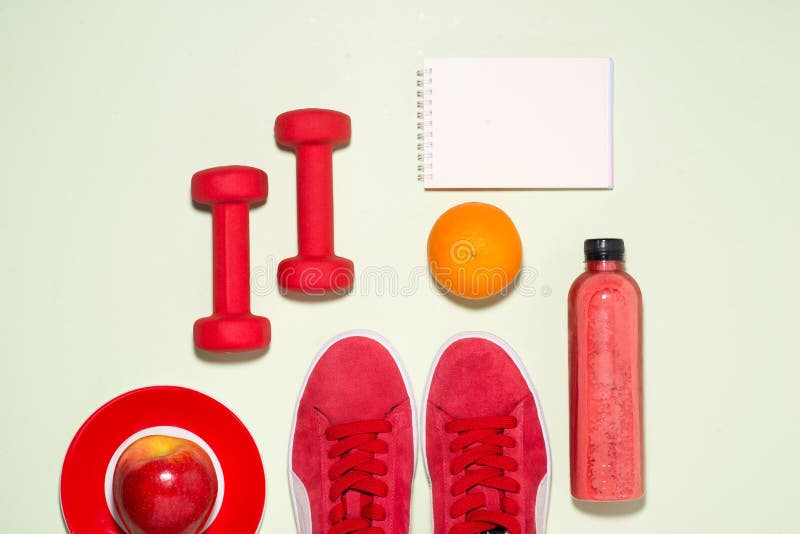 Fitness concept. Sneakers, apple, dumbbell and fruit juice bottle on pastel color background. royalty free stock image Fitness concept. Sneakers, apple, dumbbell and fruit juice bottle on pastel color background. royalty free stock image