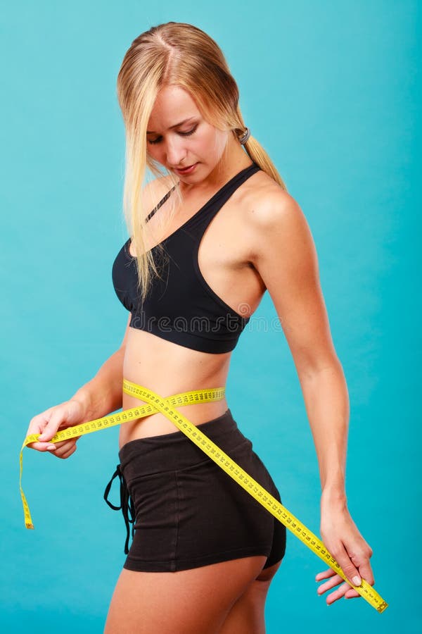 Fitness girl measuring her waistline